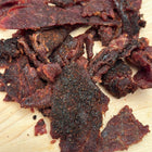 Closeup product photo of Blazed & Glazed beef jerky that shows the seasoning and marinade on the pieces of jerky.