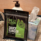 A bag of Sauce Slinger beef jerky by Heirloom Jerky sitting next to a bottle of lotion and a box of tissues. 